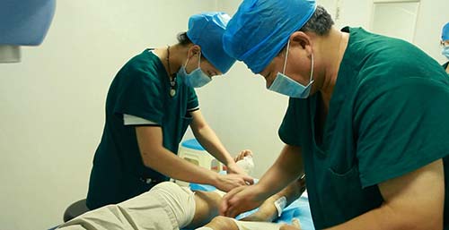 治疗医师对詹先生脚部痛风石部位恢复情况进行察看.jpg